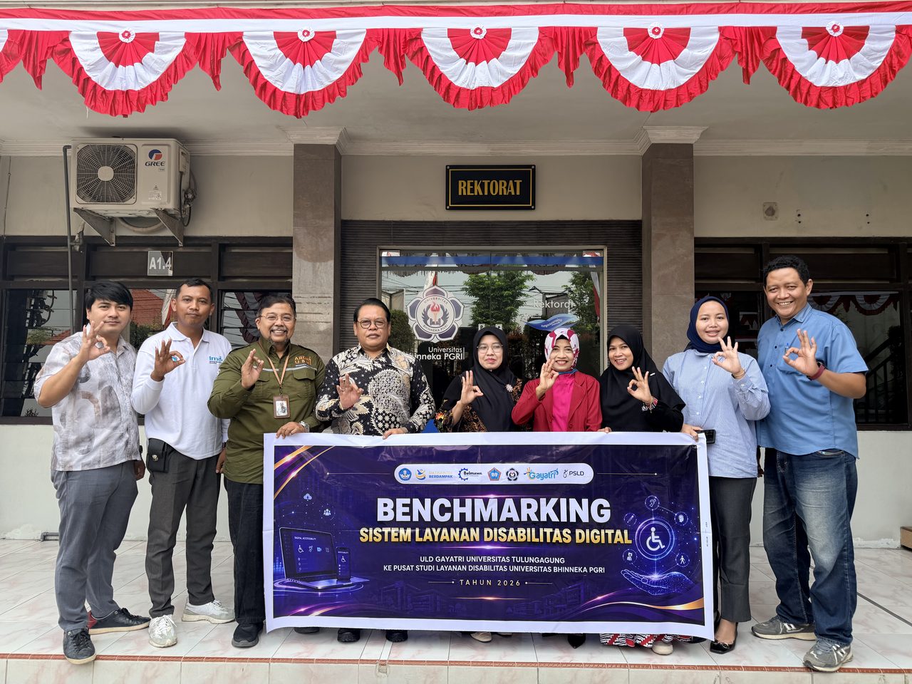 Foto grup peserta Benchmarking Sistem Asesmen Disabilitas Digital 2026 di depan gedung dengan spanduk kegiatan.